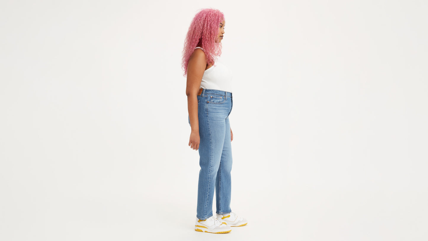 Woman in light-blue Levi's jeans and white tank top