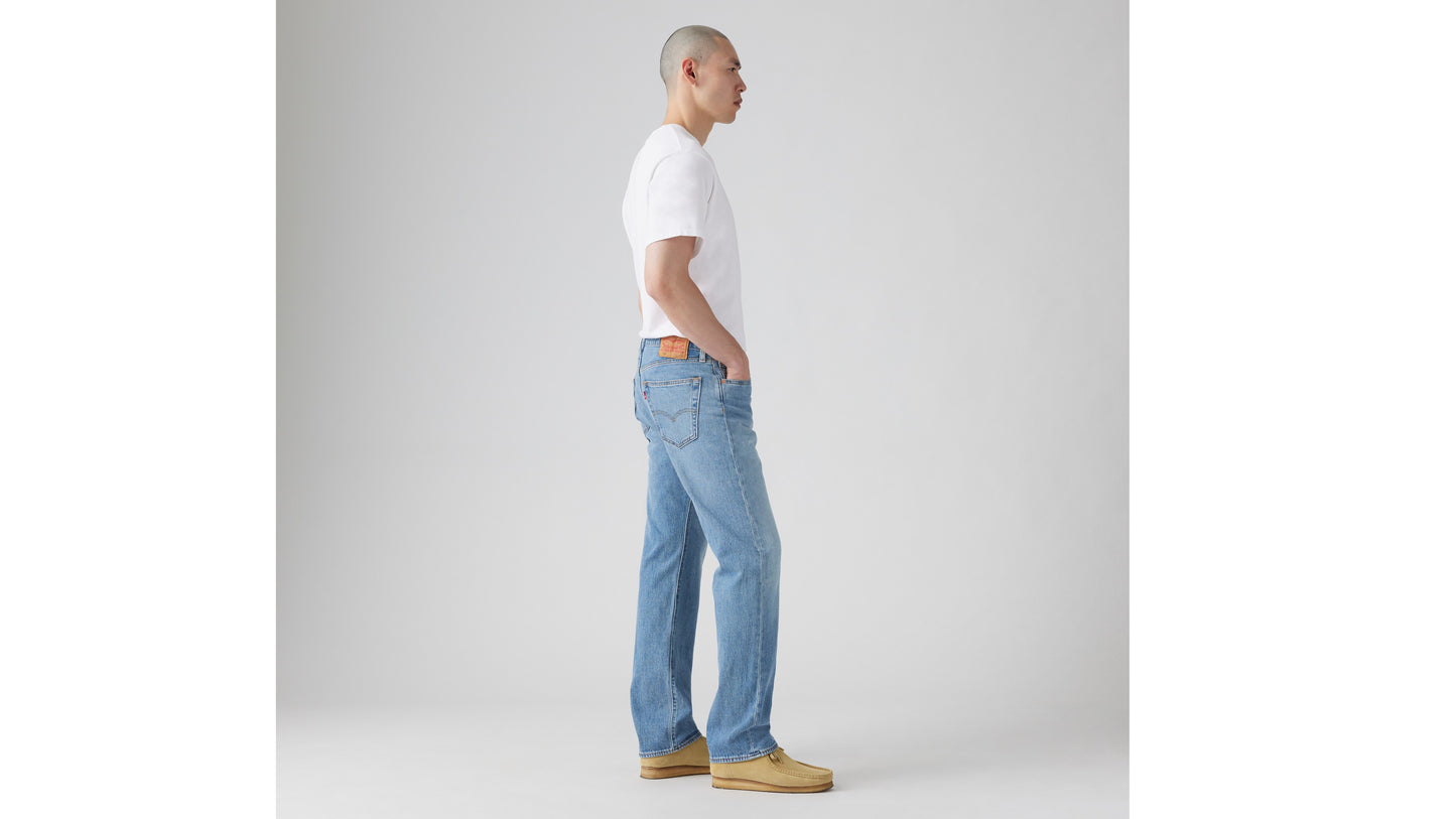 Side view of light blue Levi’s jeans with tan shoes