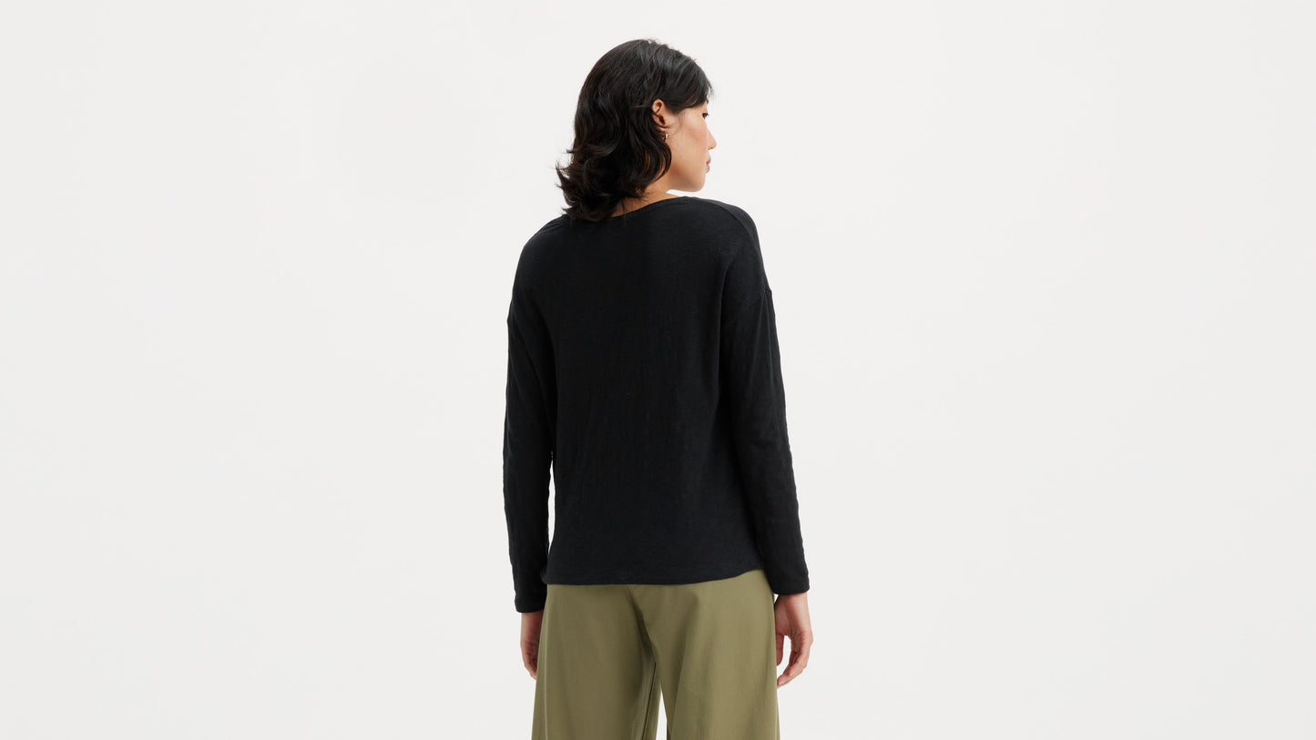 Woman in black long-sleeve top with olive-green pants