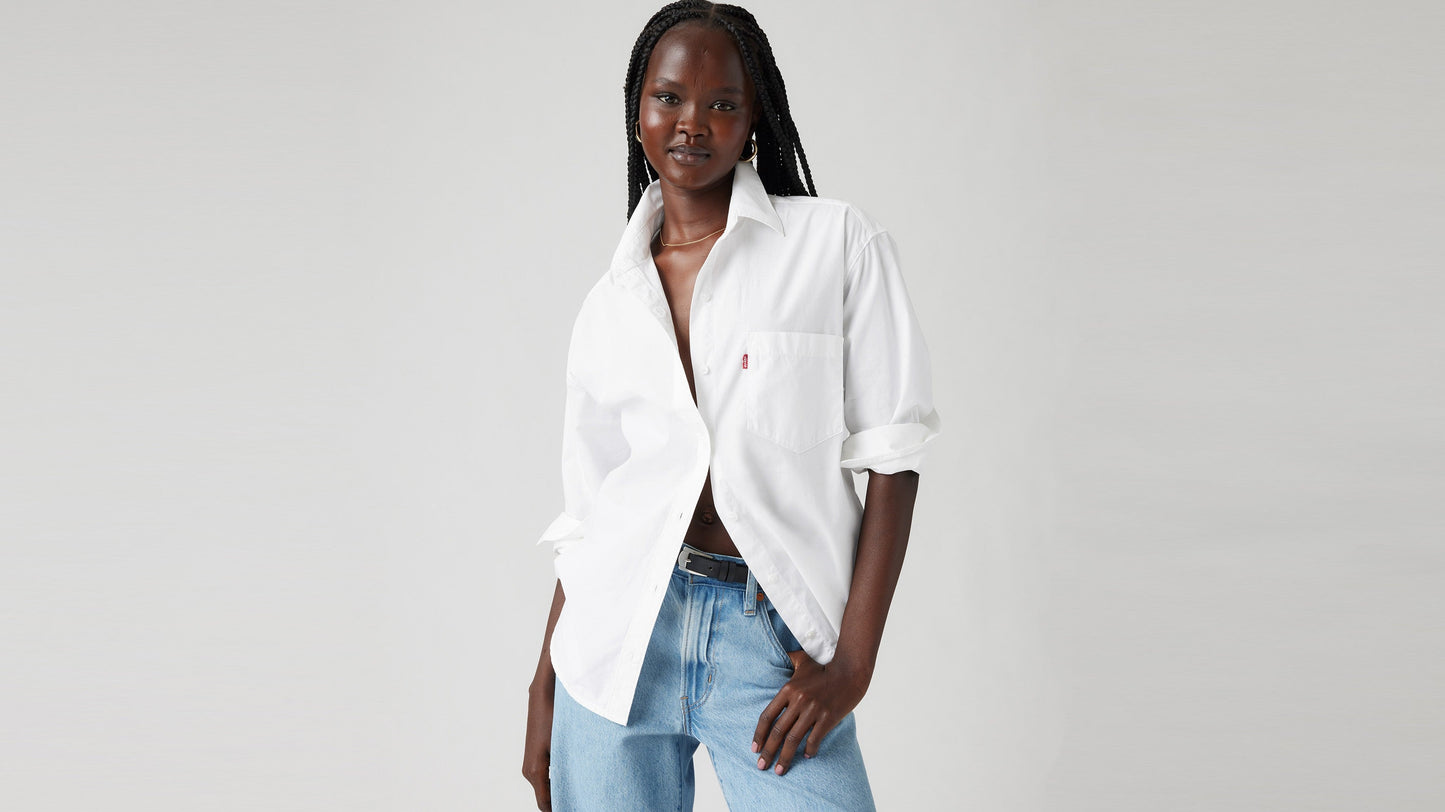 Female model wearing white long sleeve button shirt