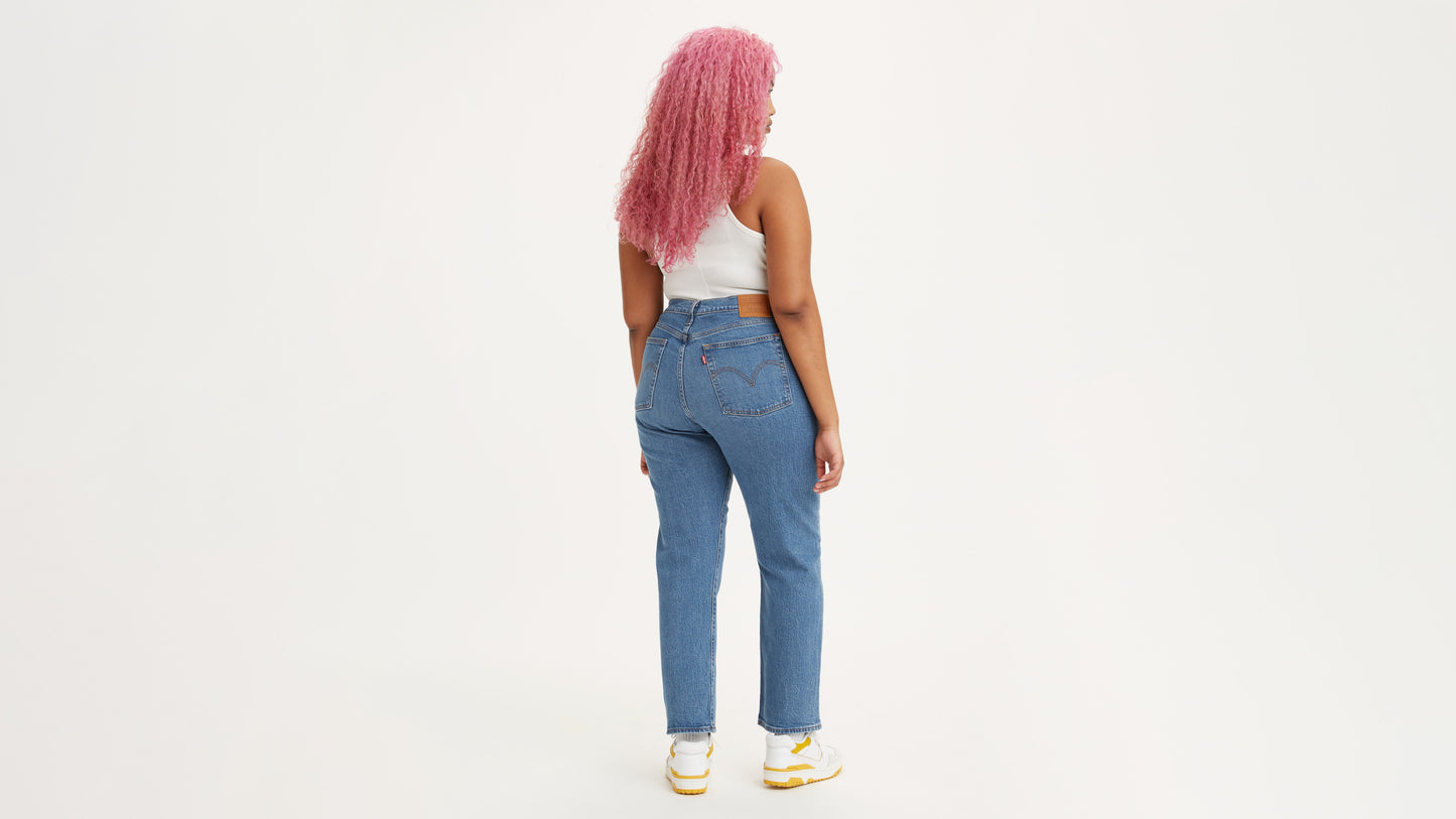 Back view woman in light-blue Levi's jeans and white tank top