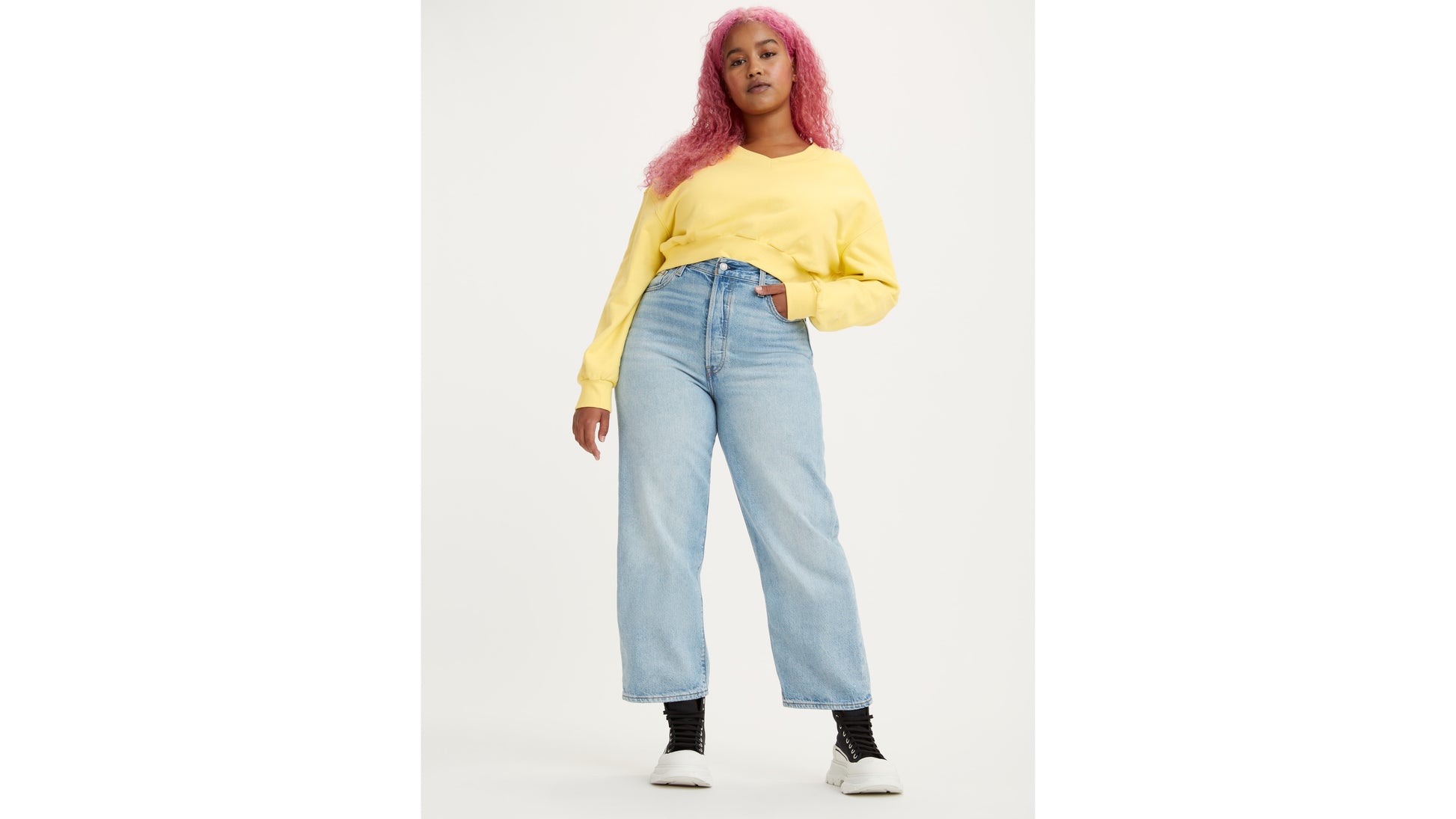 Woman in high-rise Levi's jeans and yellow sweatshirt