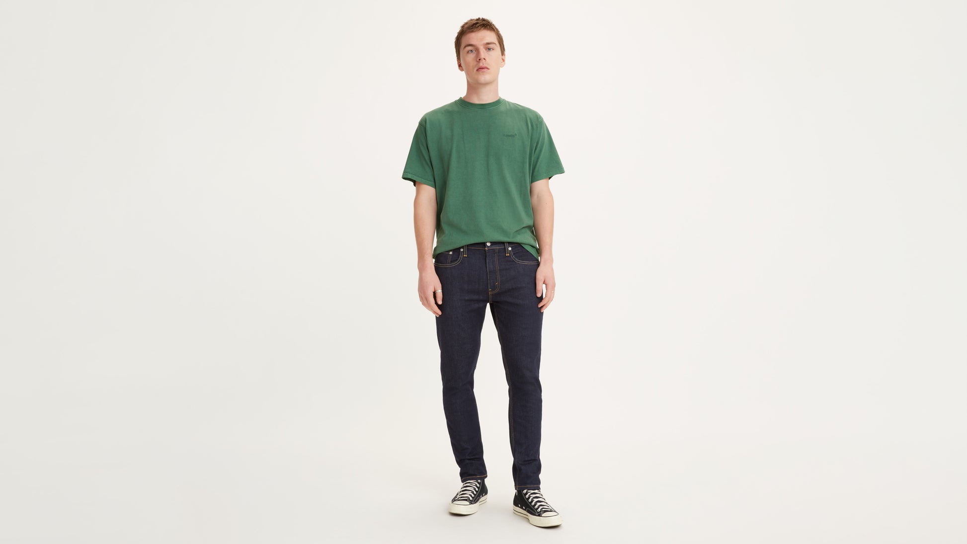 Men's dark indigo Levi's jeans and green tee