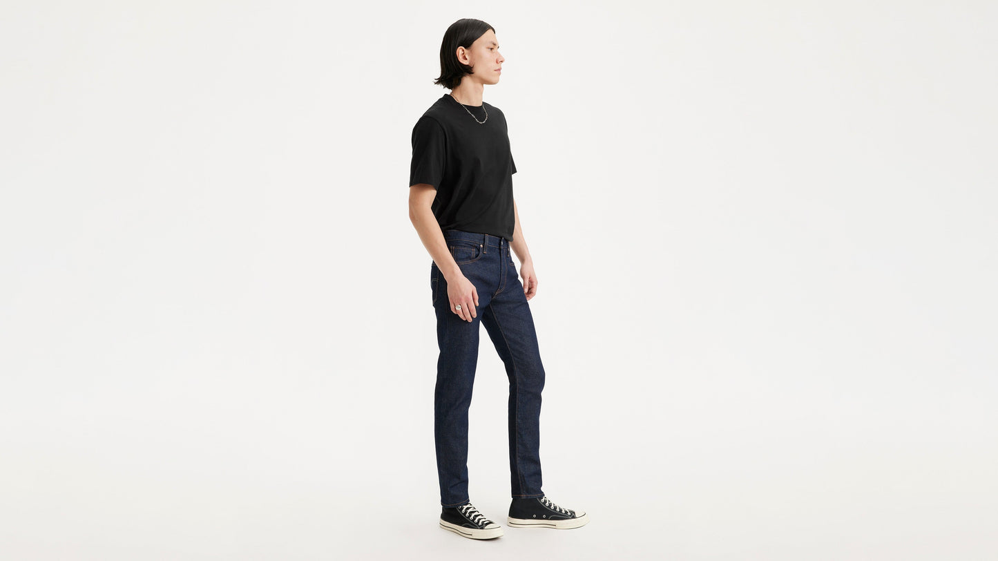 Model wearing black shirt and Levi's jeans, side view