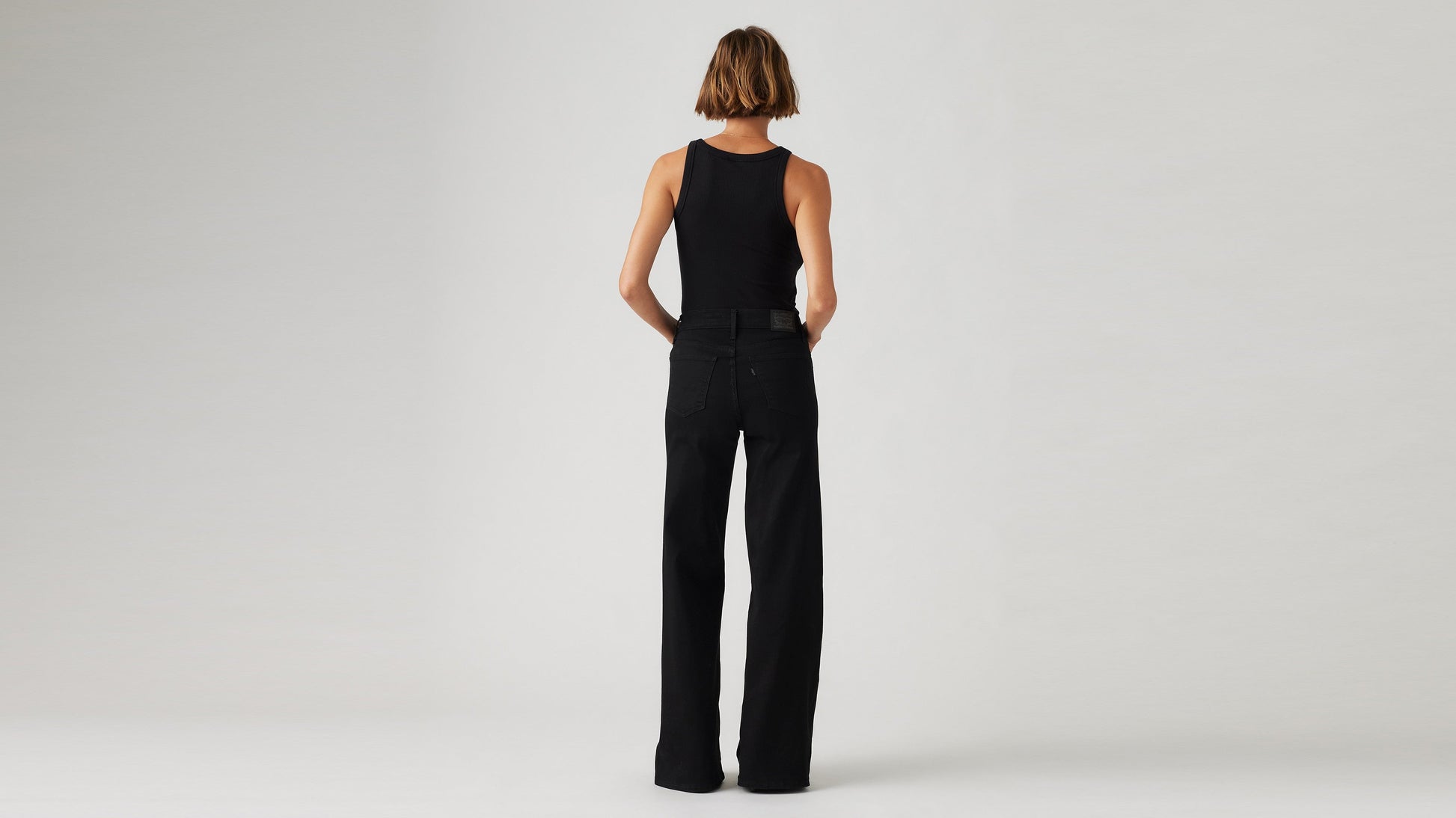 Model wearing Levi's women's black jeans, back view
