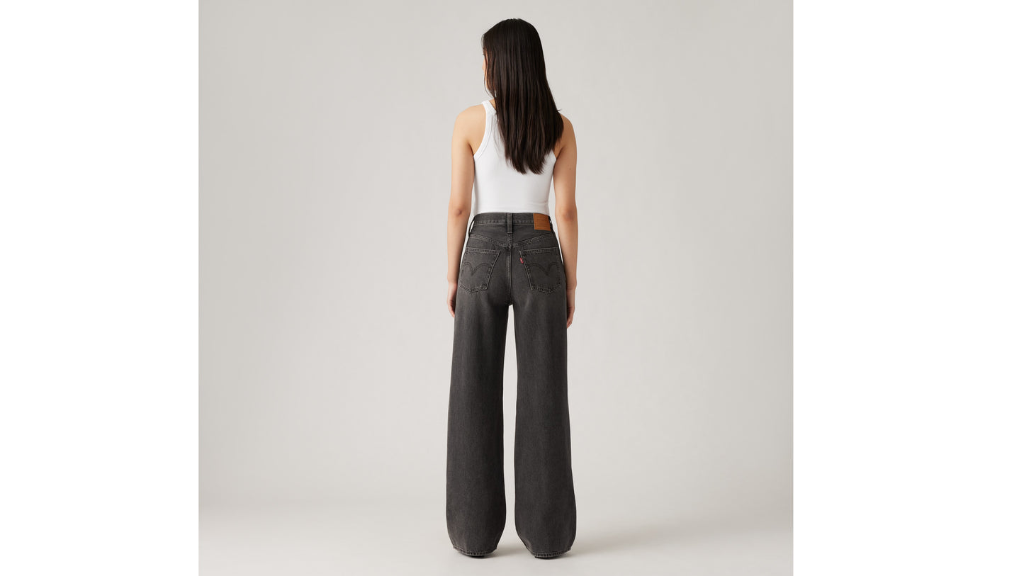 Woman in Levi's black wide-leg jeans and white tank top