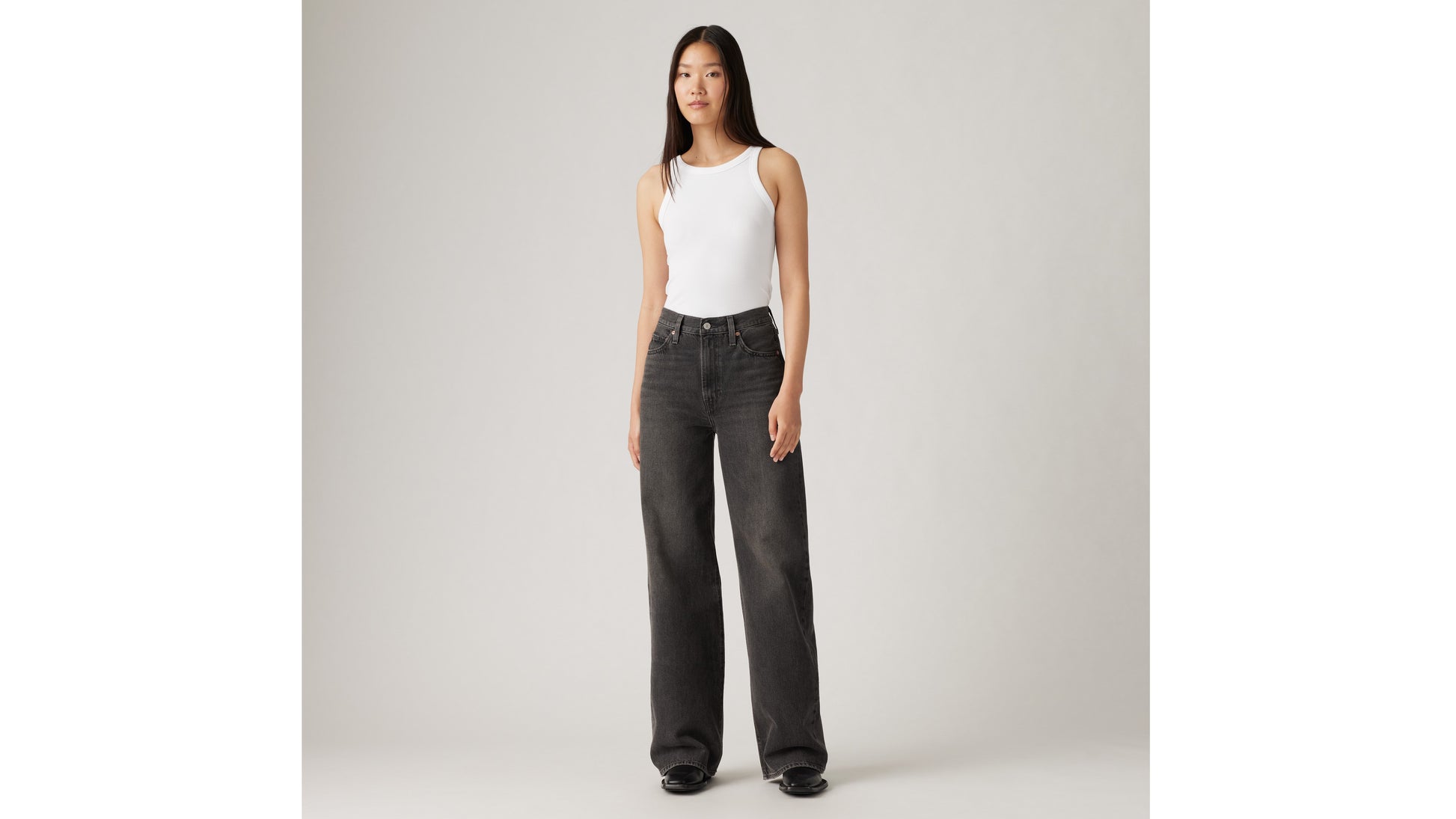 Woman in Levi's black wide-leg jeans and white tank top
