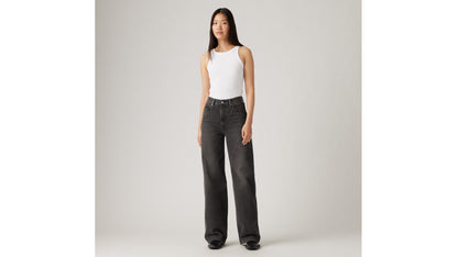 Woman in Levi's black wide-leg jeans and white tank top
