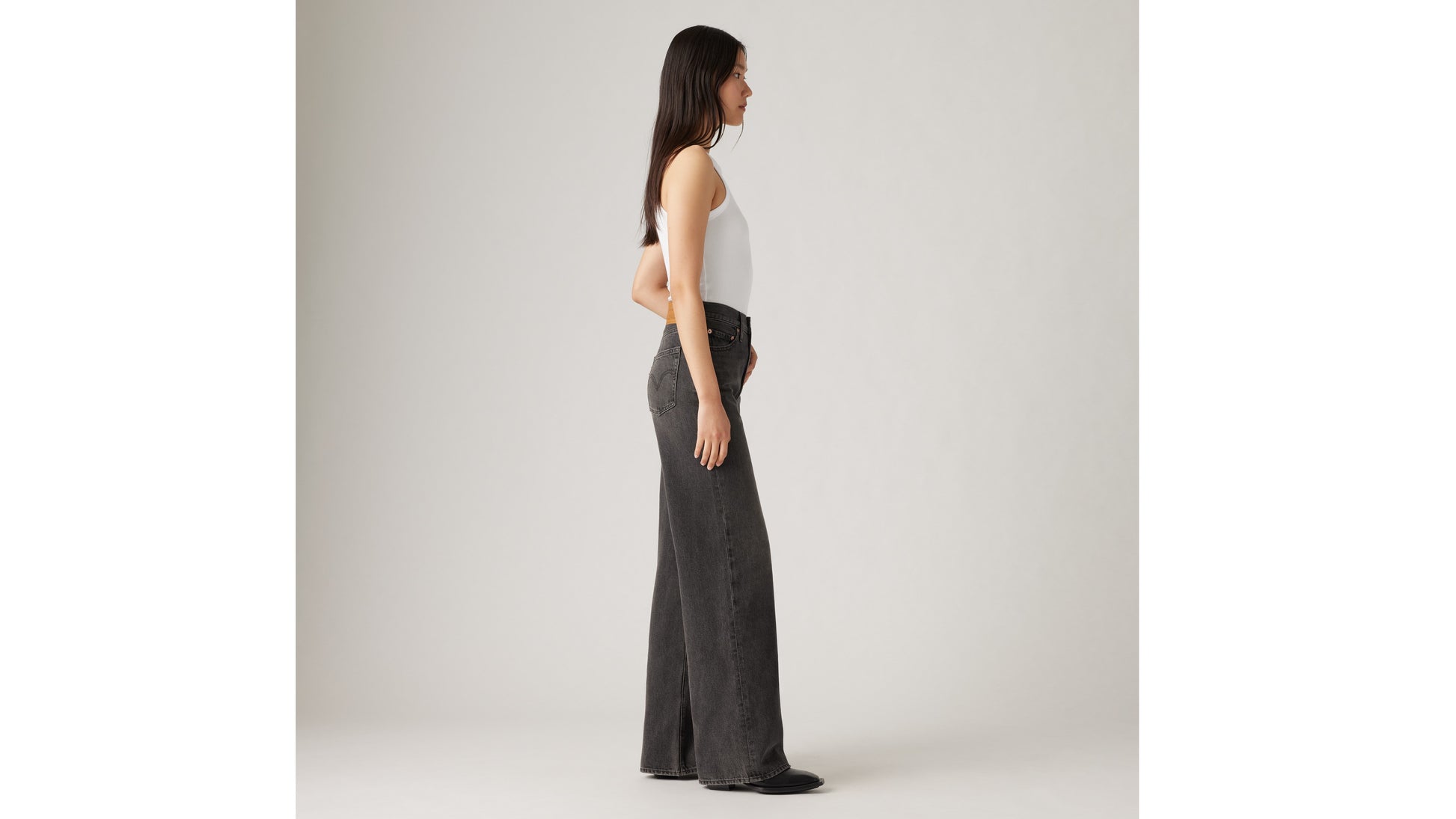 Woman in white tank top and Levi's black wide-leg jeans