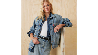Woman in layered Levi's denim jacket styled with skirt