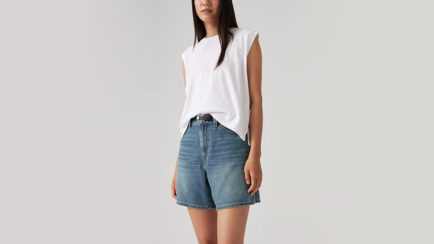 Woman in white tank with faded denim shorts