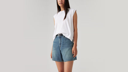 Woman in white tank with faded denim shorts