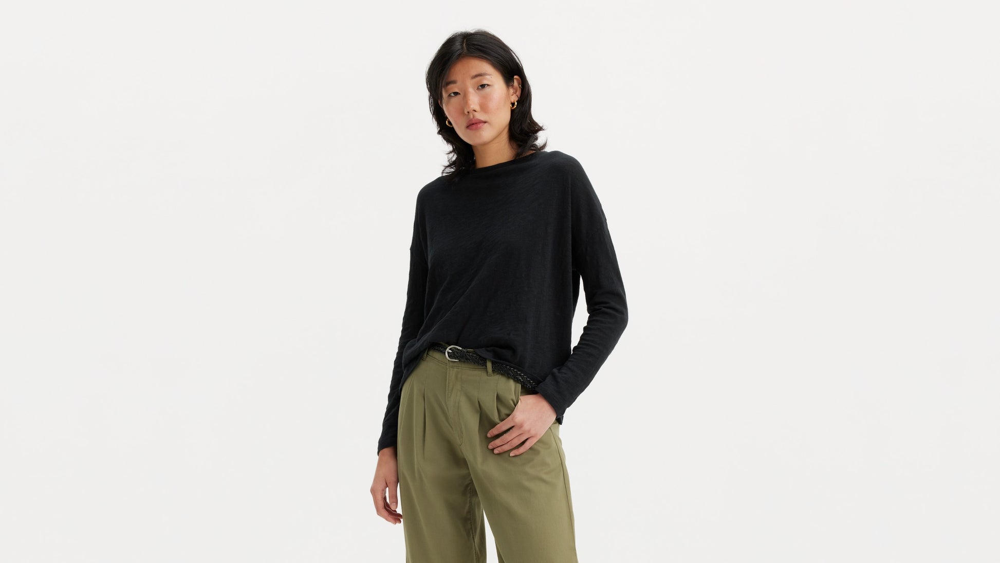 Woman in black long-sleeve top with olive pleated pants