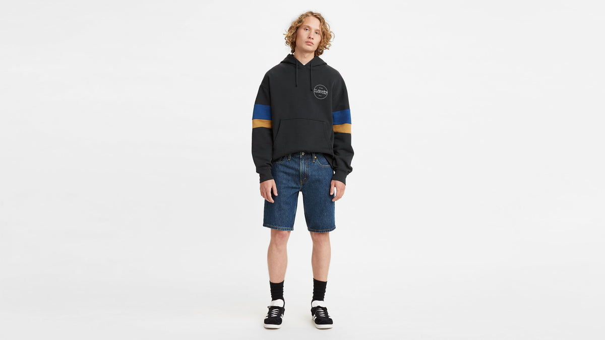 Front shot of model wearing Levi’s hoodie, denim shorts, & sneakers