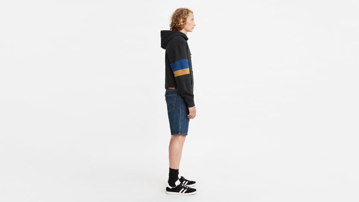 Side view of model in Levi’s color-blocked hoodie, 405 Standard Shorts, & sneakers