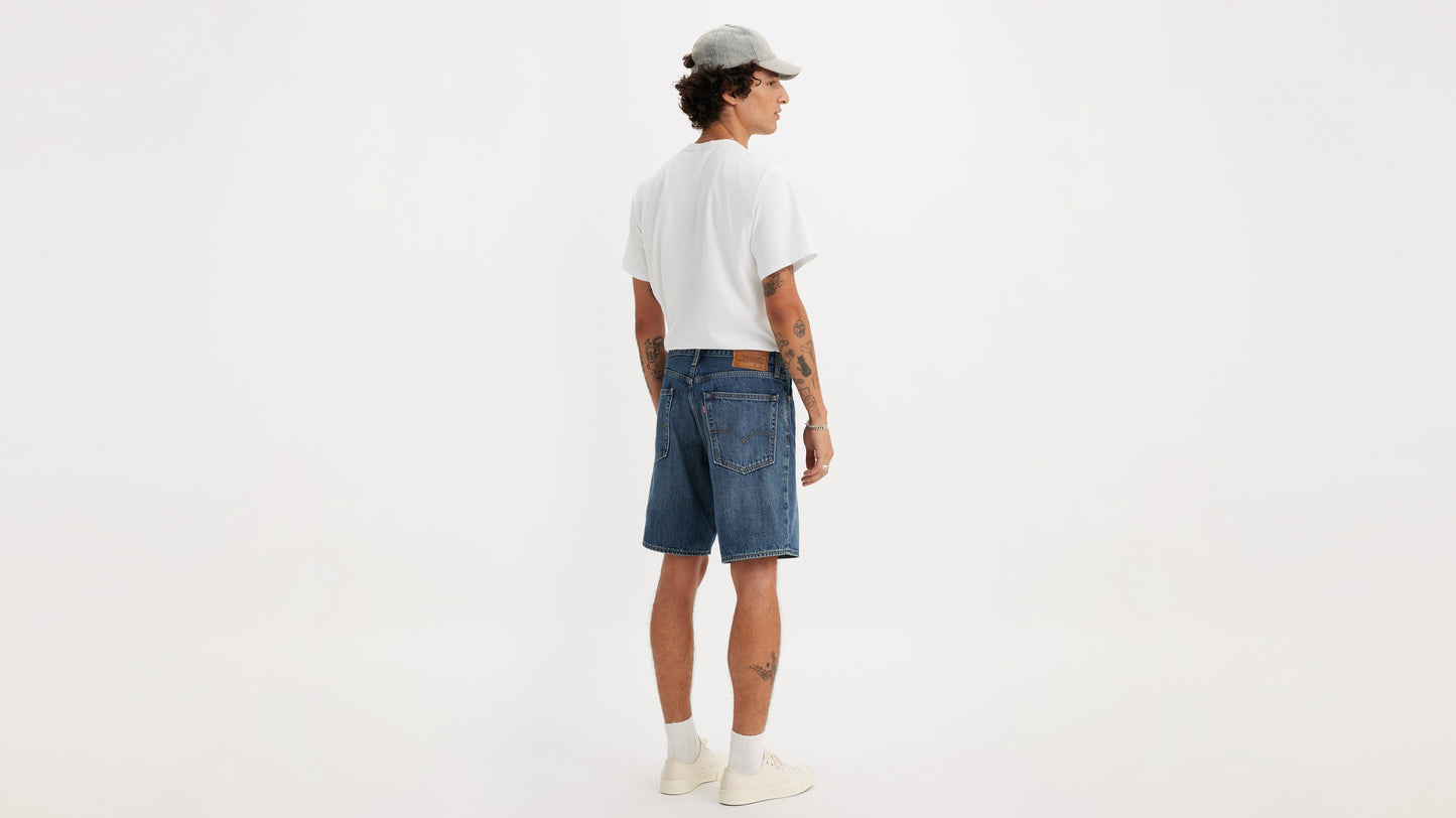 Back view of man in Levi’s 468 Shorts paired with white tee, cap, & sneakers