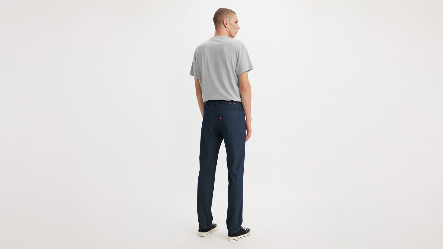 Back view of model in Levi’s navy slim tech pants and grey tee