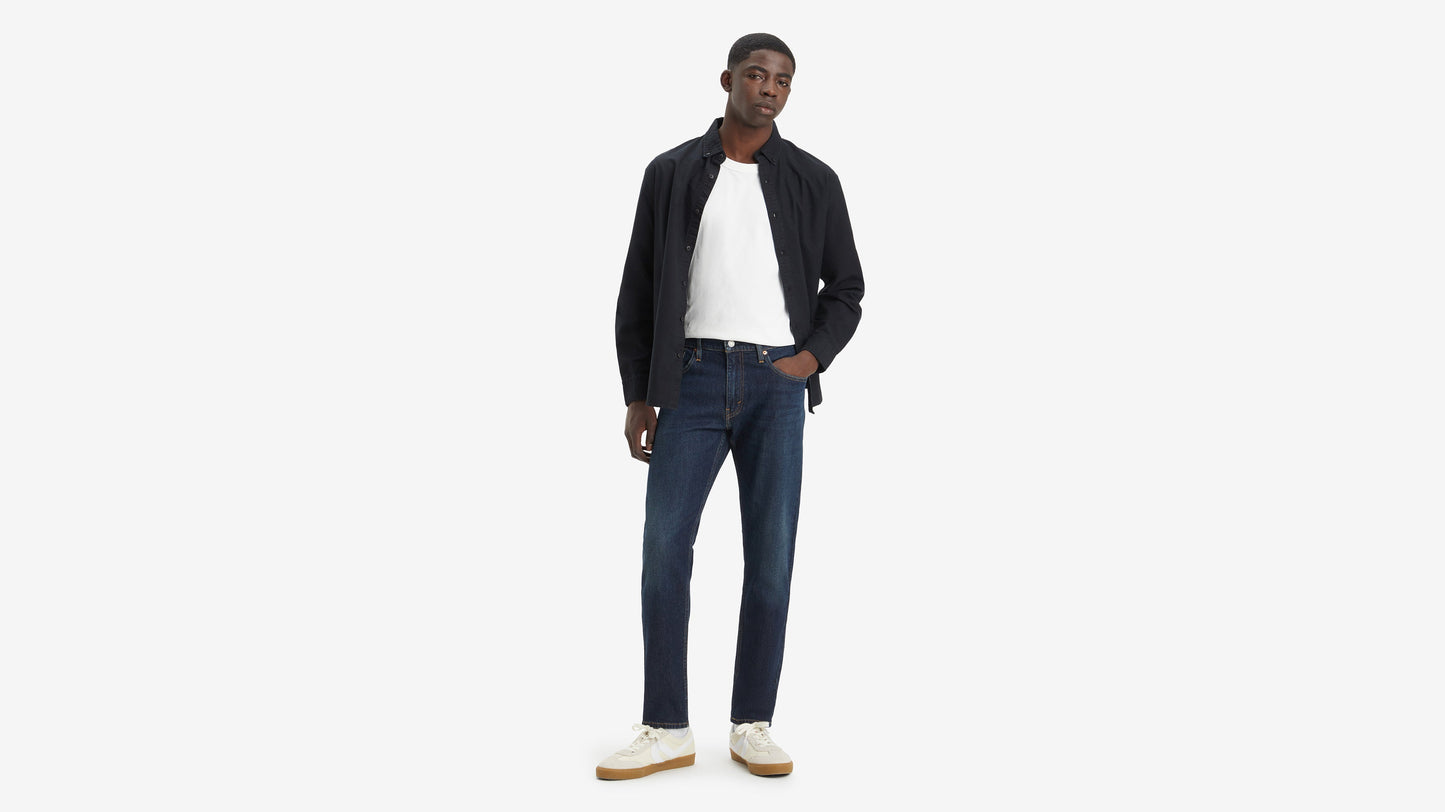 Front-facing shot of model in Levi’s 512 jeans tanding with one hand in pocket