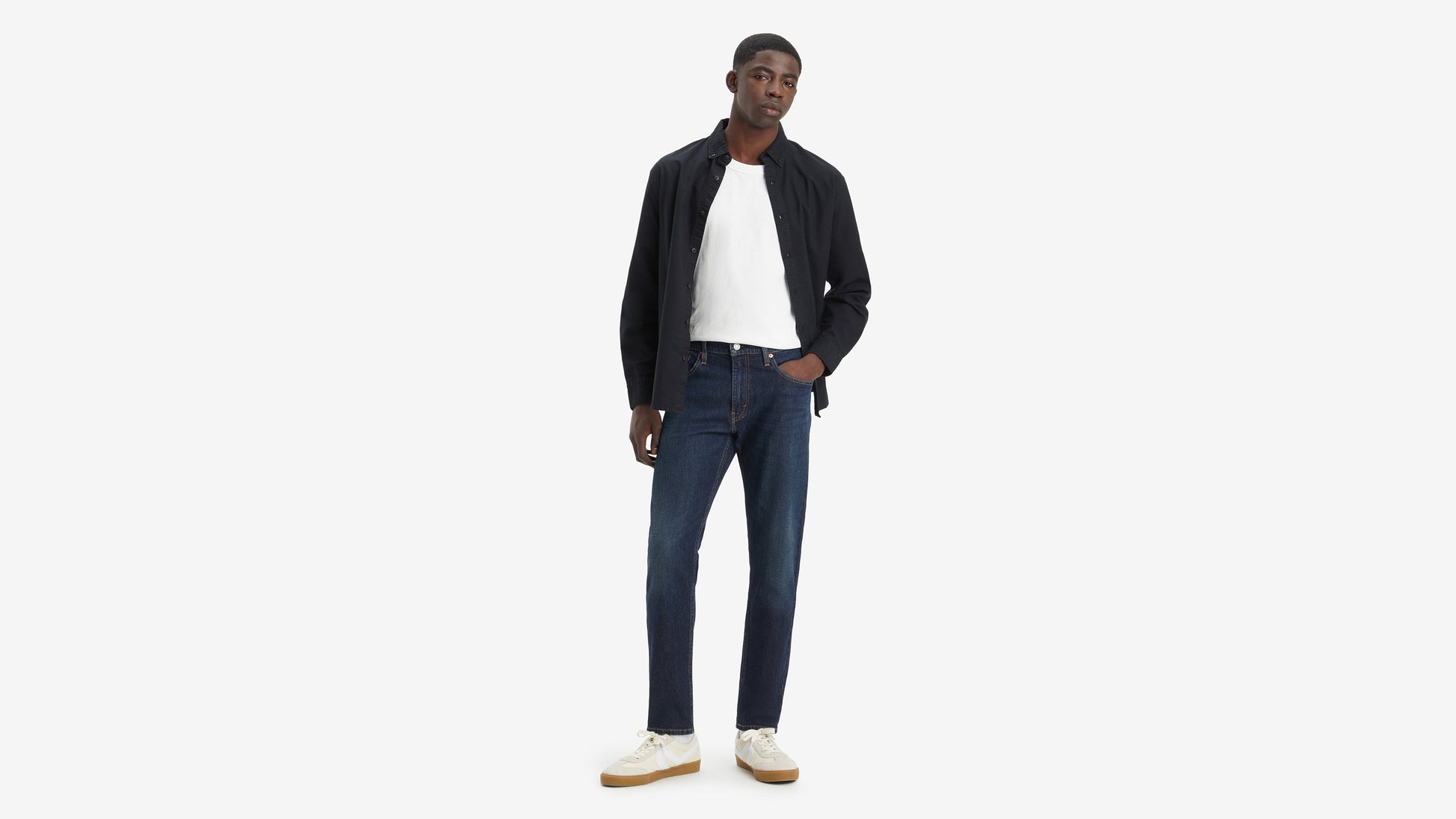Front-facing shot of model in Levi’s 512 jeans tanding with one hand in pocket