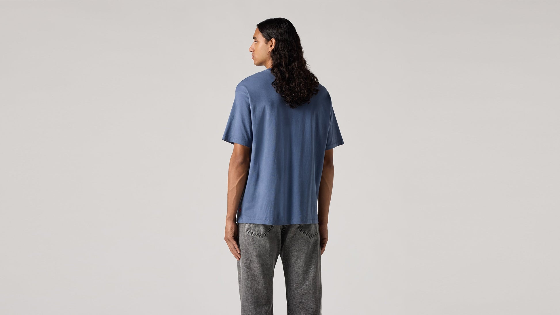 Back view of man in blue round tshirt and gray jeans