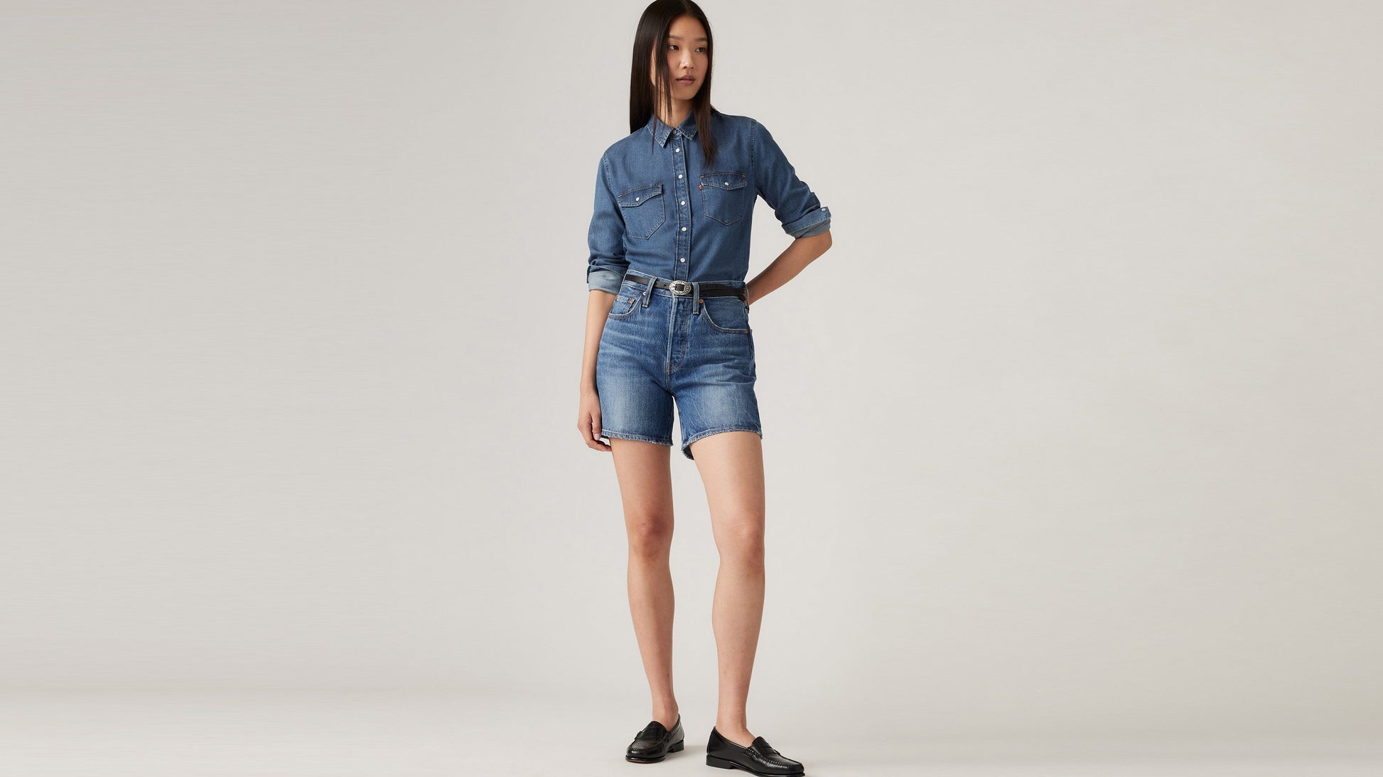 Woman in Levi's mid thigh shorts, long sleeves denim and loafers