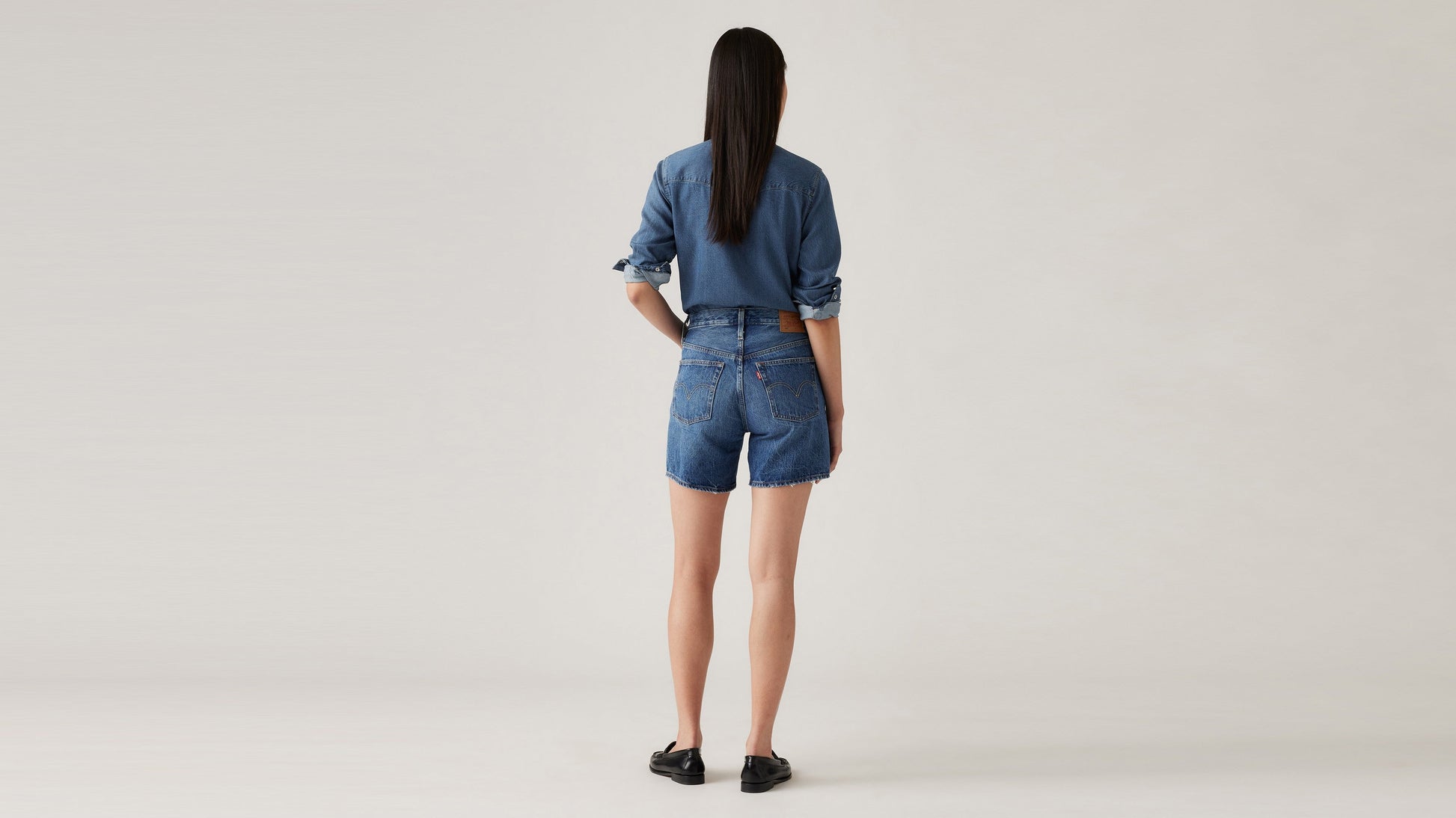 Back view of Woman in Levi's mid thigh shorts and long sleeves