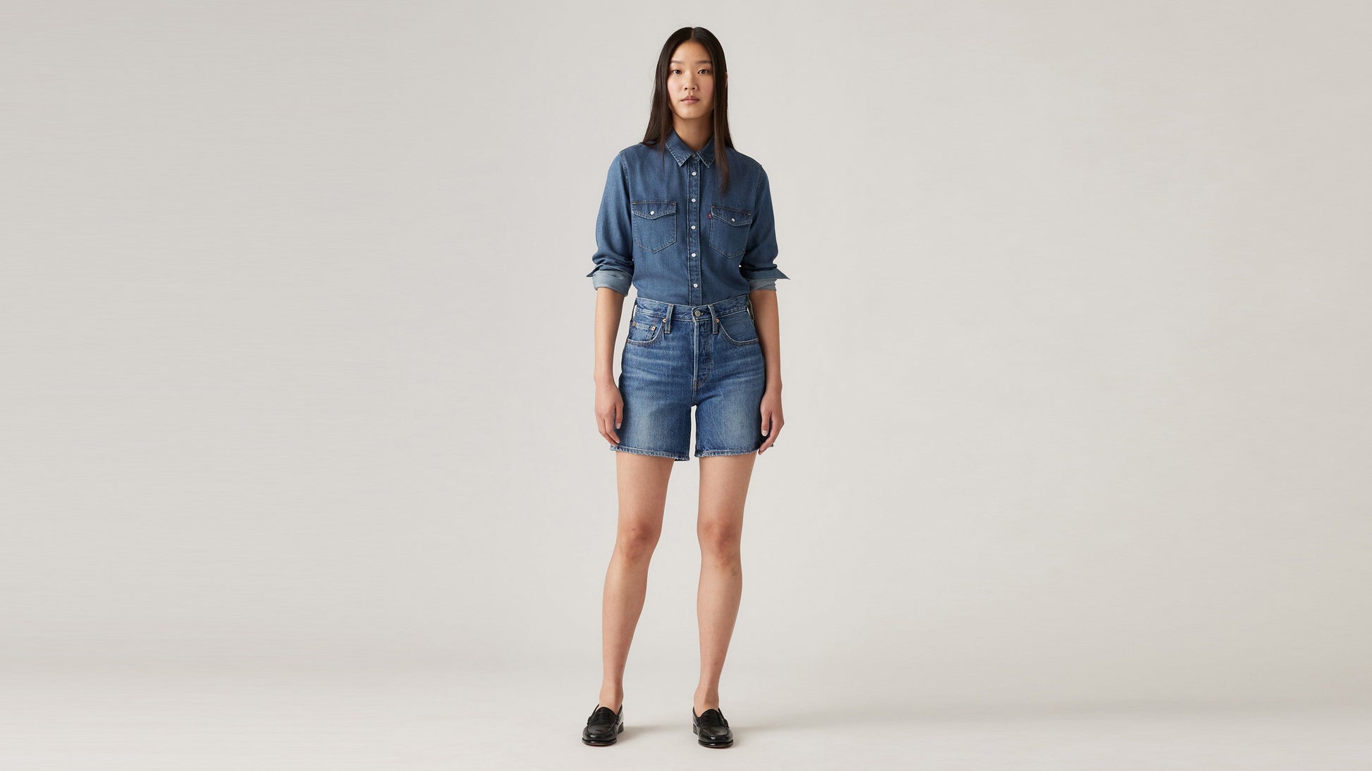 Woman in Levi's womens mid thigh shorts and long sleeves denim