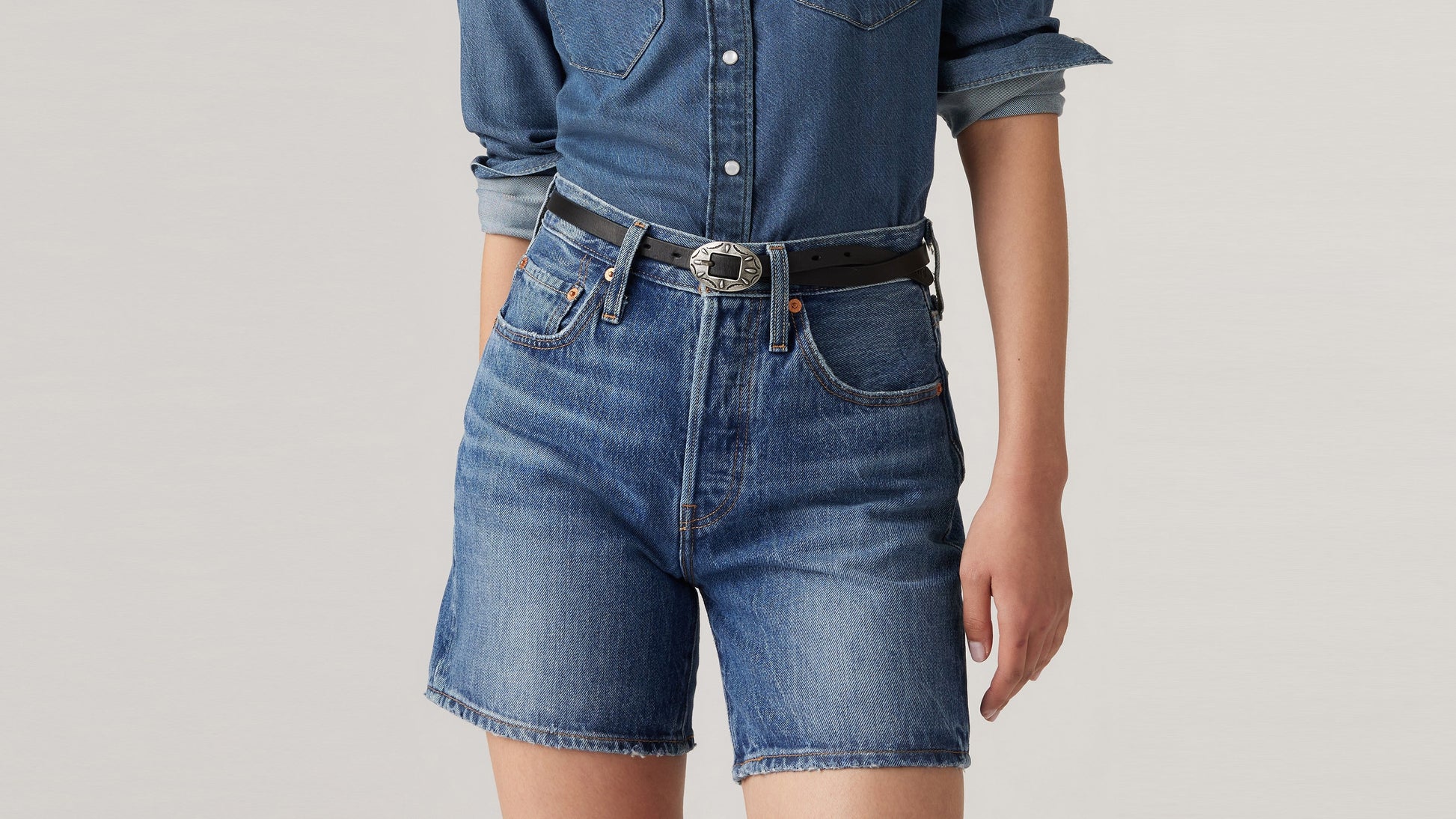 Close up view of blue Levi's womens mid thigh shorts