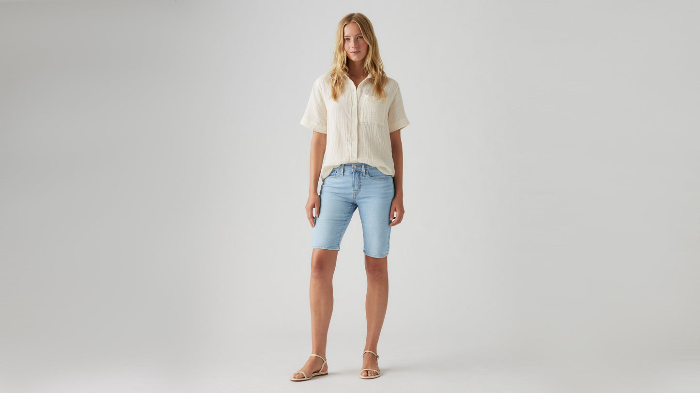 Woman wearing faded blue bermuda shorts front view