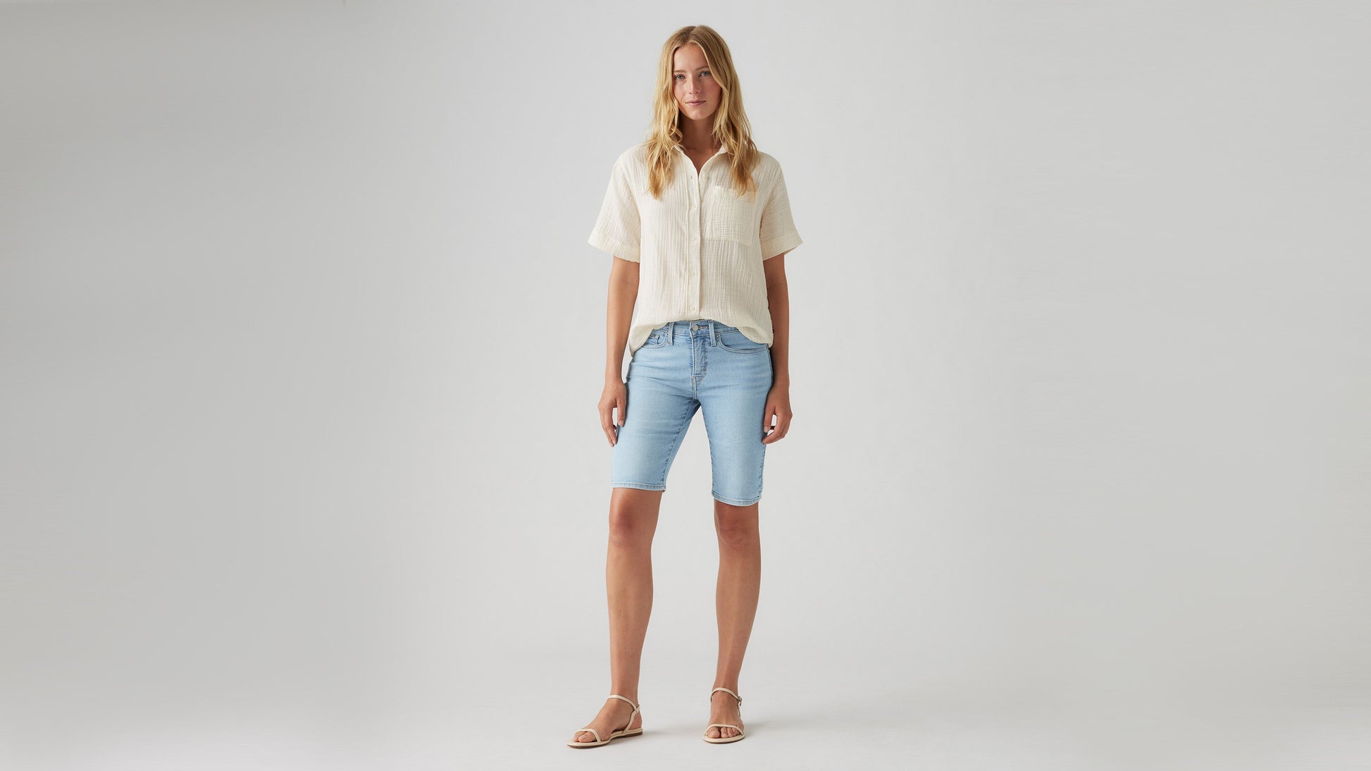 Woman wearing faded blue bermuda shorts front view