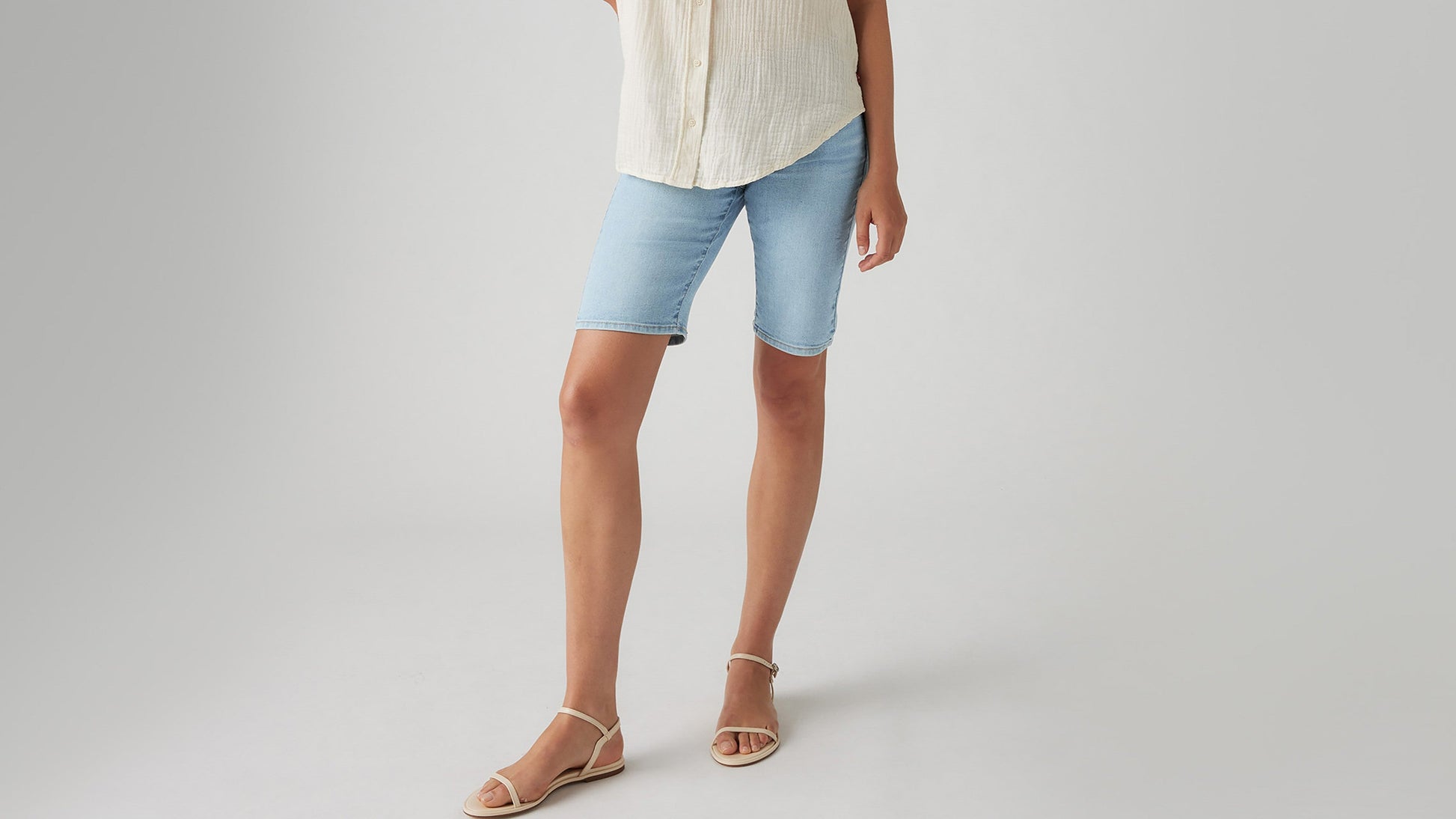 Close-up view of womens faded blue bermuda shorts